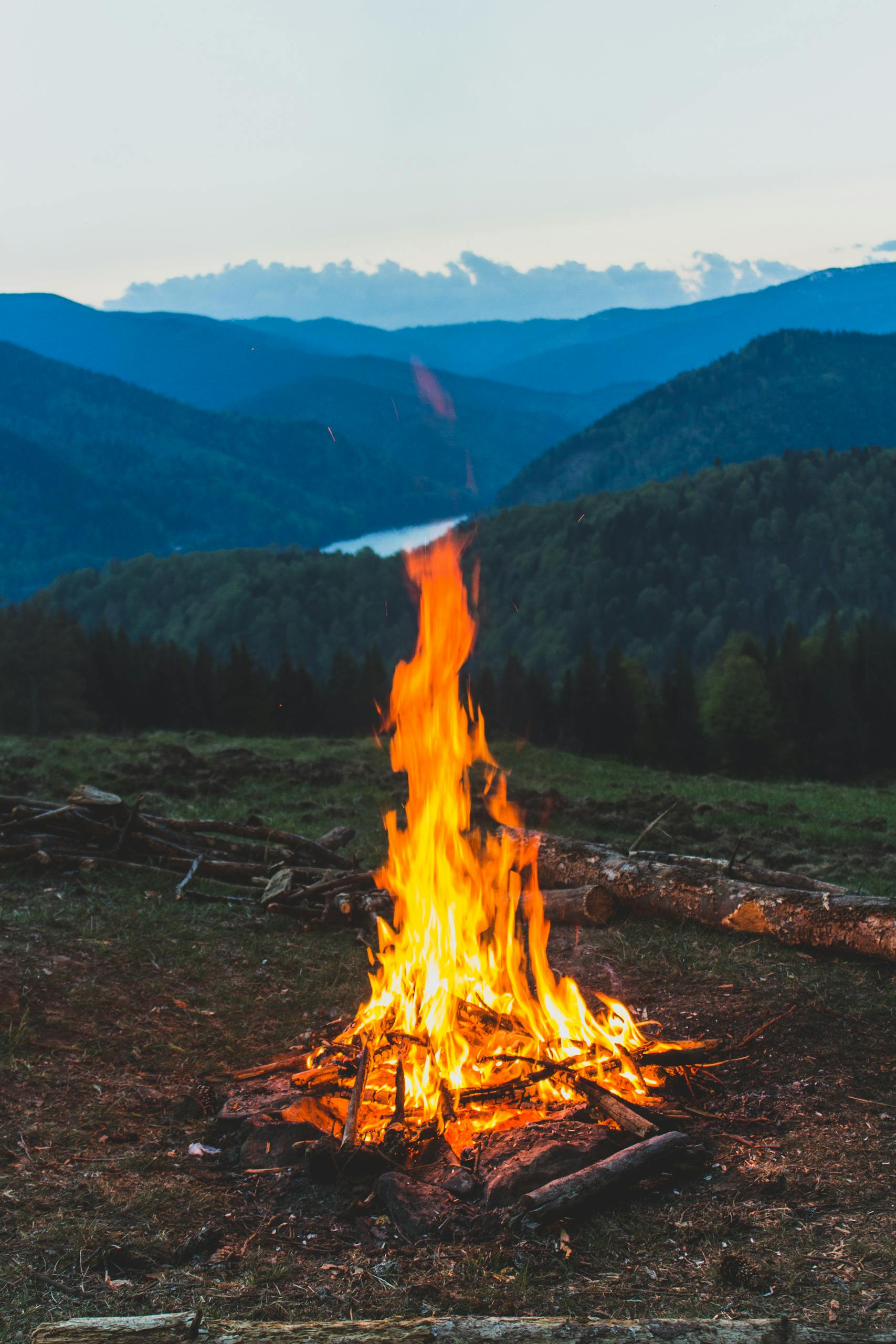 A serene campfire with a stunning mountain backdrop.